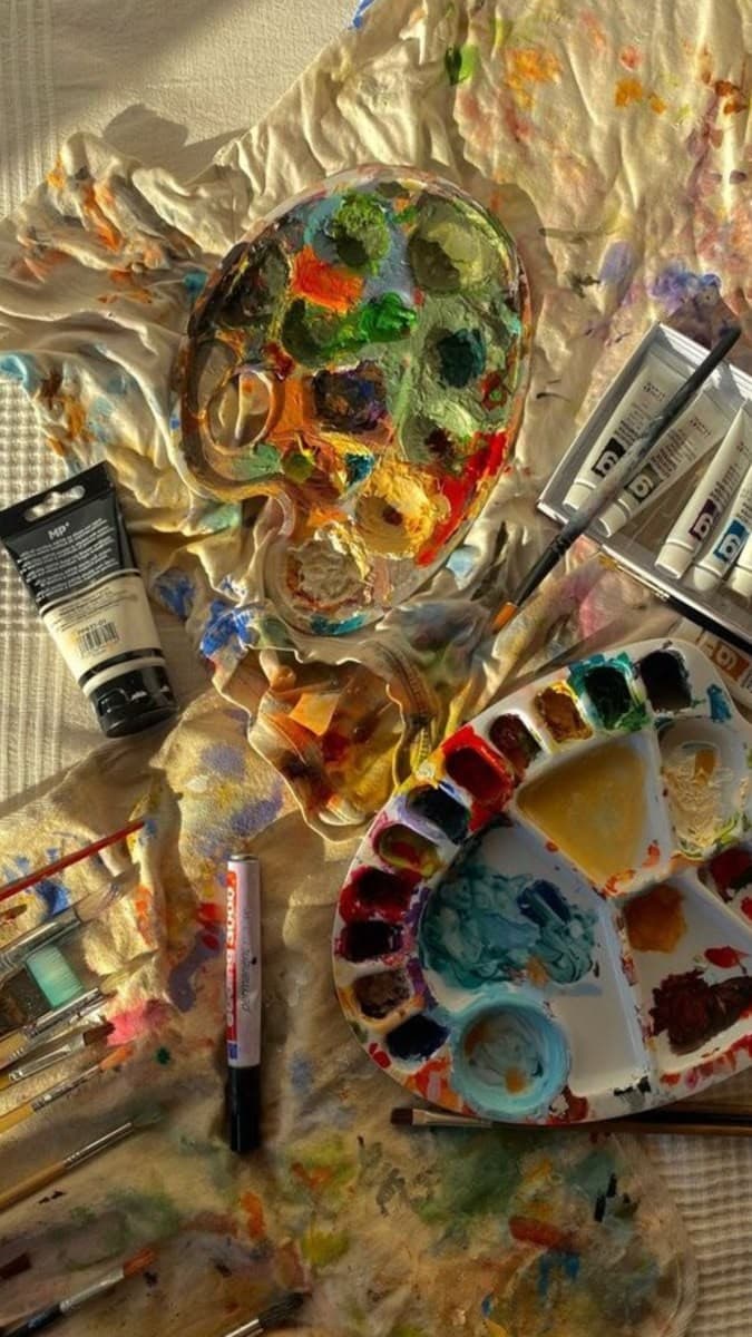 Paint palettes, tubes and brushes on a cloth
