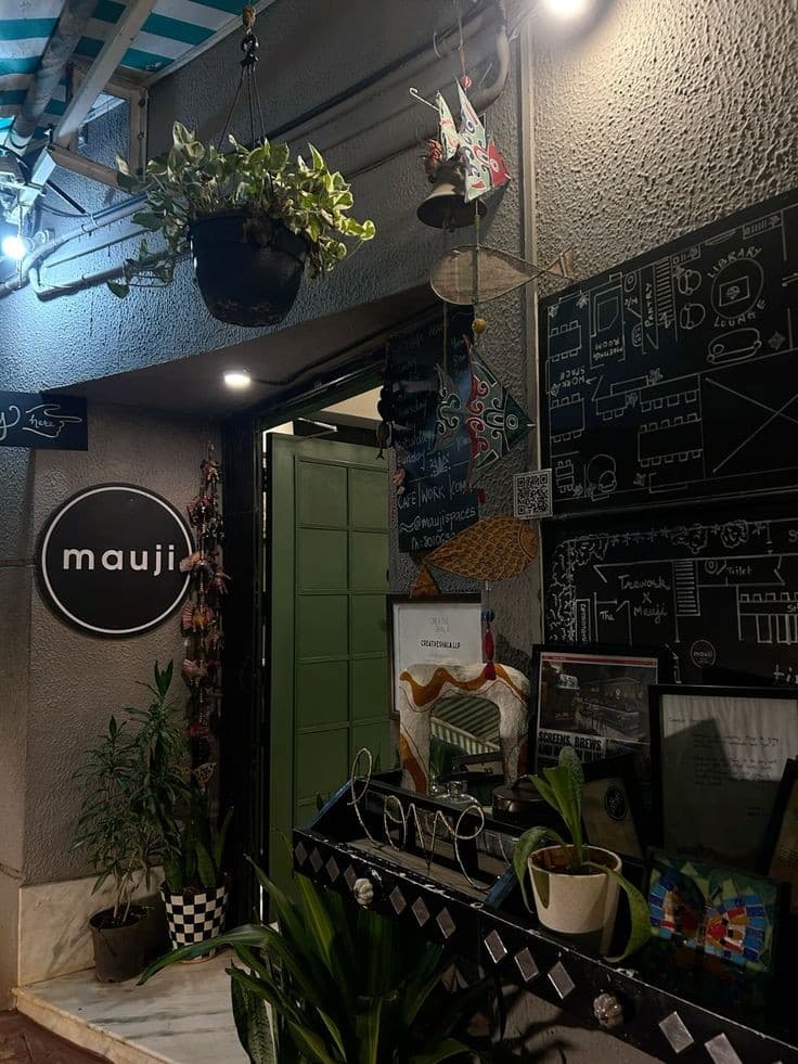 Entrance of a small café with plants and a chalkboard