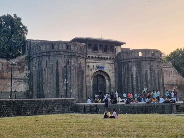Shaniwar Wada fort at dusk with people on the lawn